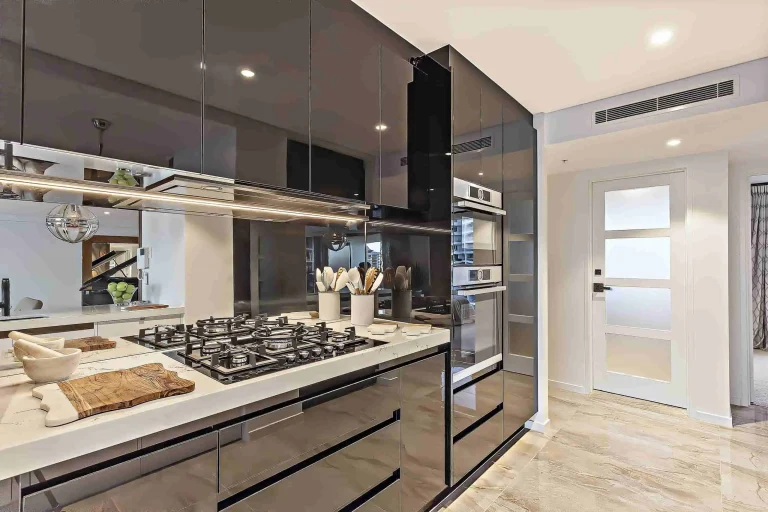Cocina moderna con elegantes gabinetes de alto brillo y electrodomésticos de acero inoxidable