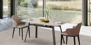Elegante tavolo da pranzo allungabile con sedie beige che mostrano semplicità e stile in una stanza luminosa e naturale