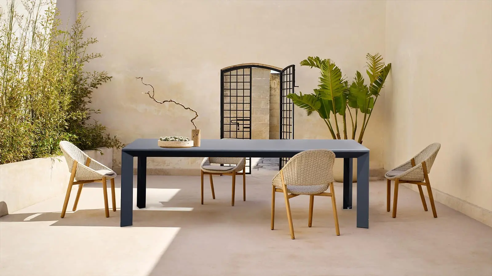 Elegant ceramic table set in a serene patio surrounded by lush plants and minimalist decor perfect for outdoor dining