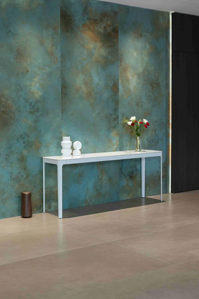 a sleek minimalist white ceramic table set against a vibrant textured wall that gives the space a modern artistic flair