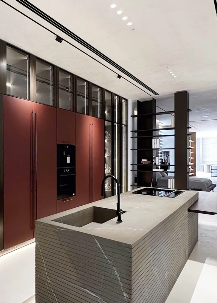 Modern kitchen with sleek red cabinets a central island with an integrated sink and open shelving in a contemporary design
