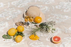 Summer table with lemons grapefruit flowers and hat