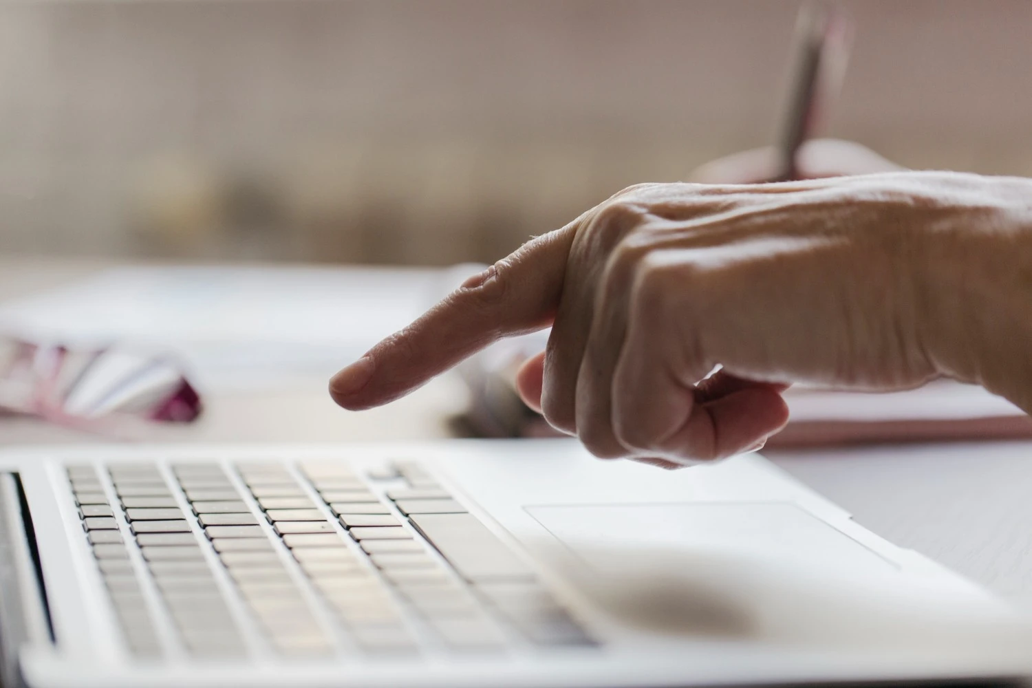Close up of a hand pointing to a laptop keyboard symbolizing the Inquiry Submission process for initiating contact with our team