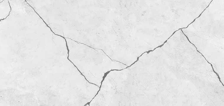 Close up view of a cracked concrete surface with visible fissures