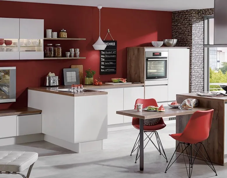 This image showcases a contemporary kitchen with a striking red accent wall that adds warmth and vibrancy to the space