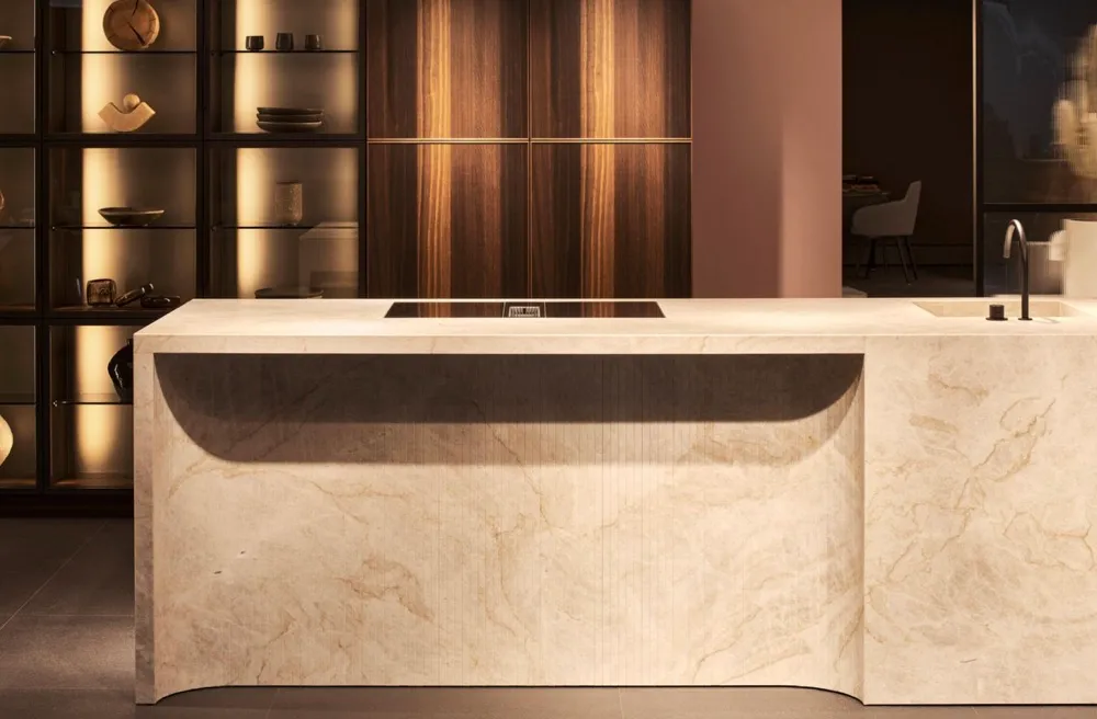 This image showcases a luxurious kitchen with a striking island made of a beautiful light colored marble
