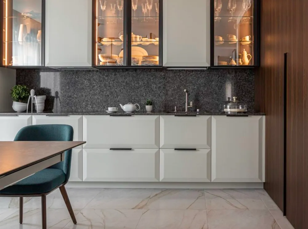 This image showcases a modern kitchen with a combination of sleek white cabinetry and a dark granite backsplash and countertop