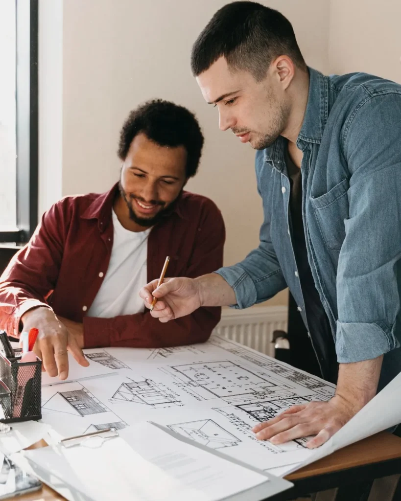 Two designers collaborating over home design drawings