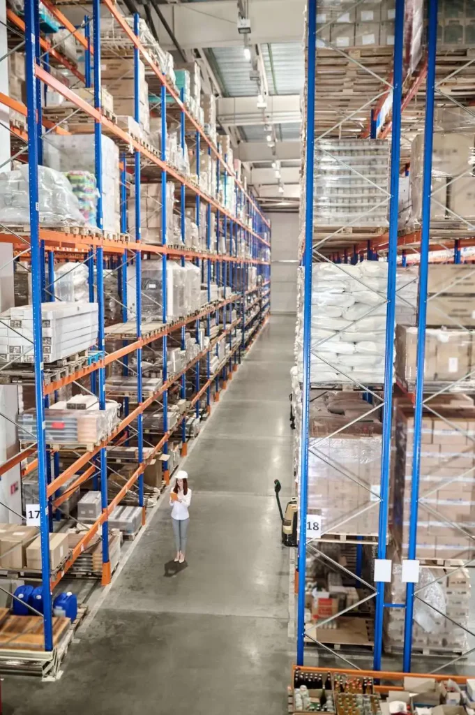 a warehouse with tall shelves filled with various furniture items representing furniture distribution logistics