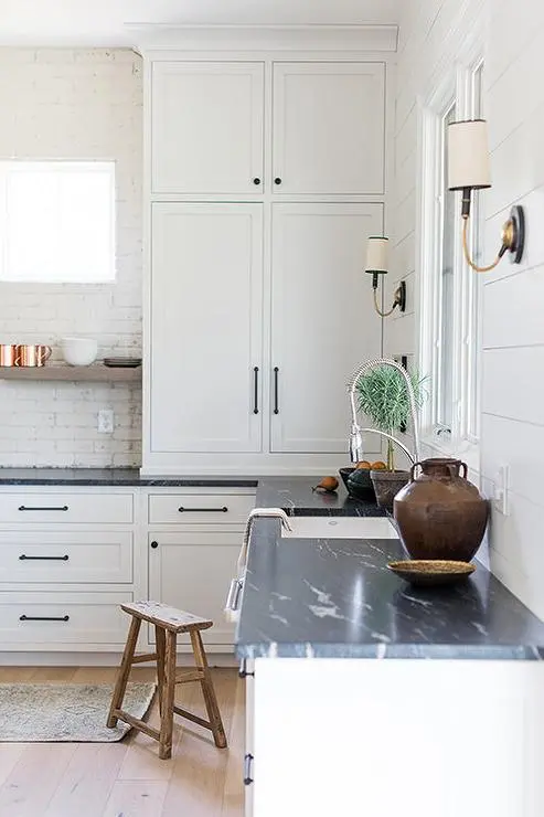 A close up view of a kitchen with honed black soapstone countertops white cabinetry and a bright clean design A close up view of a kitchen with honed black soapstone countertops white cabinetry and a bright clean design