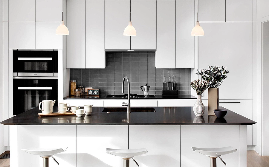 A sleek kitchen design showcasing black quartz countertops with a subway glass backsplash and white cabinets A sleek kitchen design showcasing black quartz countertops with a subway glass backsplash and white cabinets