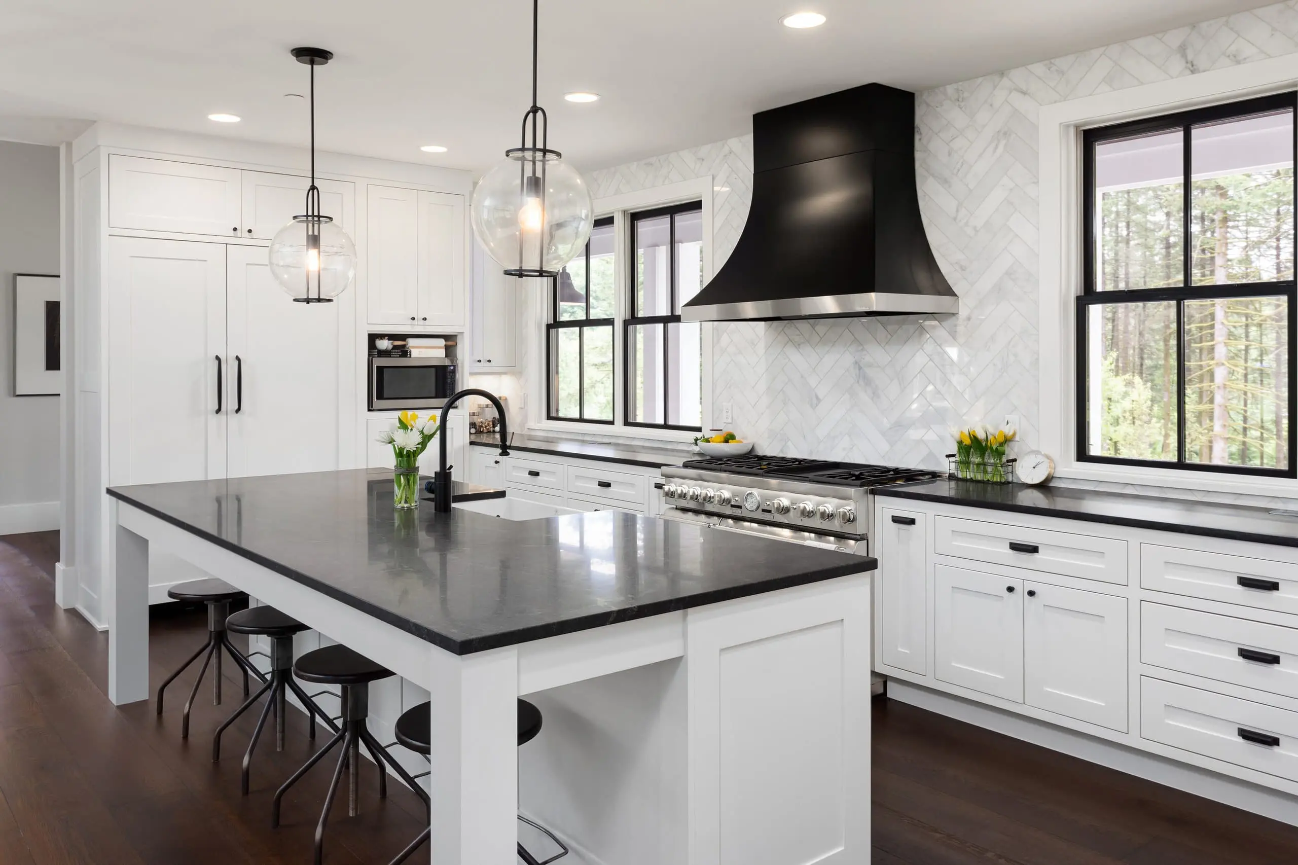 A stylish kitchen and family room with a blend of black white and wood elements creating an elegant and modern atmosphere A stylish kitchen and family room with a blend of black white and wood elements creating an elegant and modern atmosphere