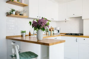 Bright small kitchen with a wooden countertop and lilac flowers