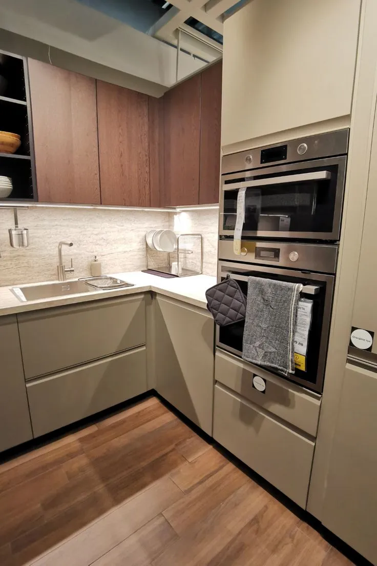 Compact taupe kitchen cabinets with stainless steel appliances for a modern efficient layout