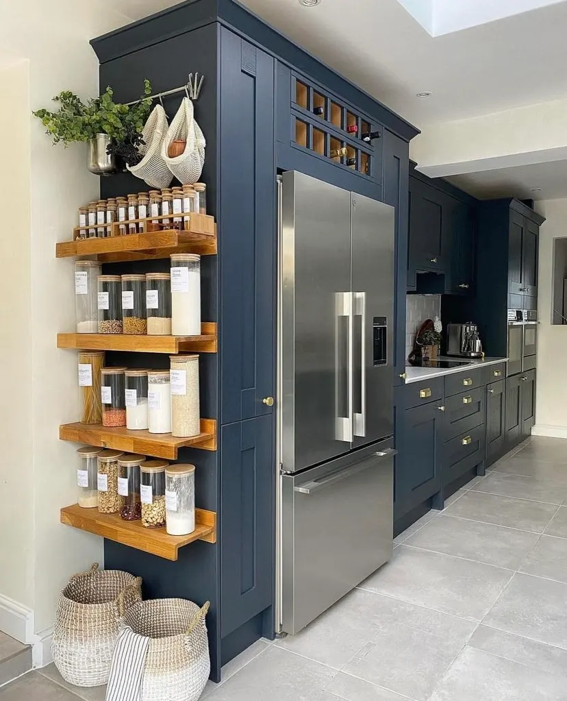 Dark cabinets with vertical wooden shelves stainless fridge
