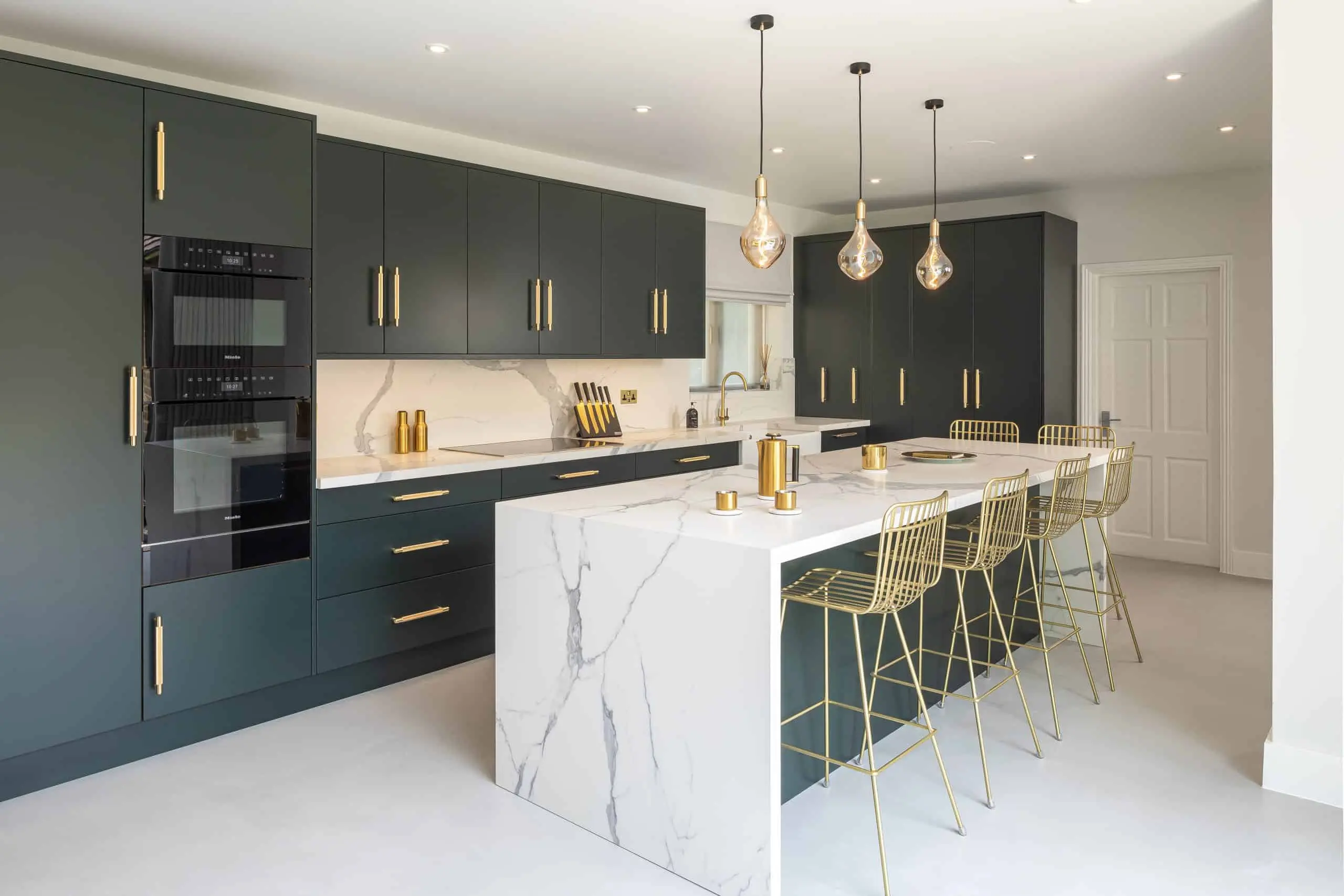 Eco friendly modern kitchen cabinets with gold accents and a marble island countertop Eco friendly modern kitchen cabinets with gold accents and a marble island countertop