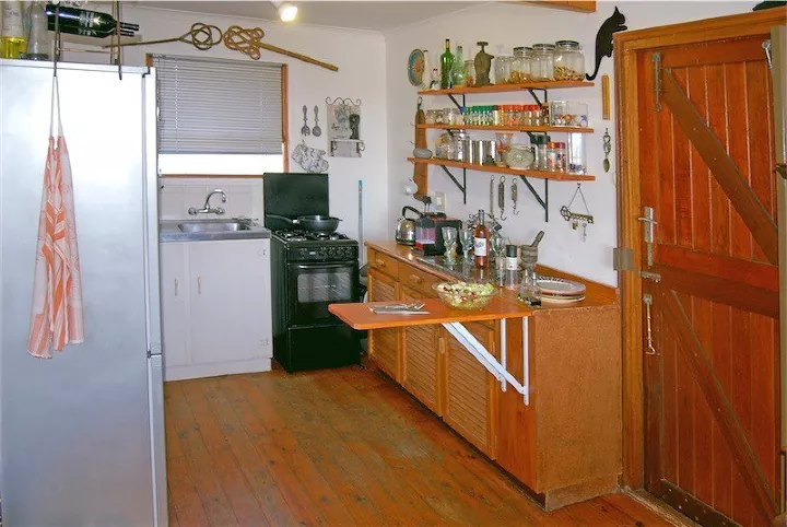 Fold down countertop in a small kitchen with wood cabinets