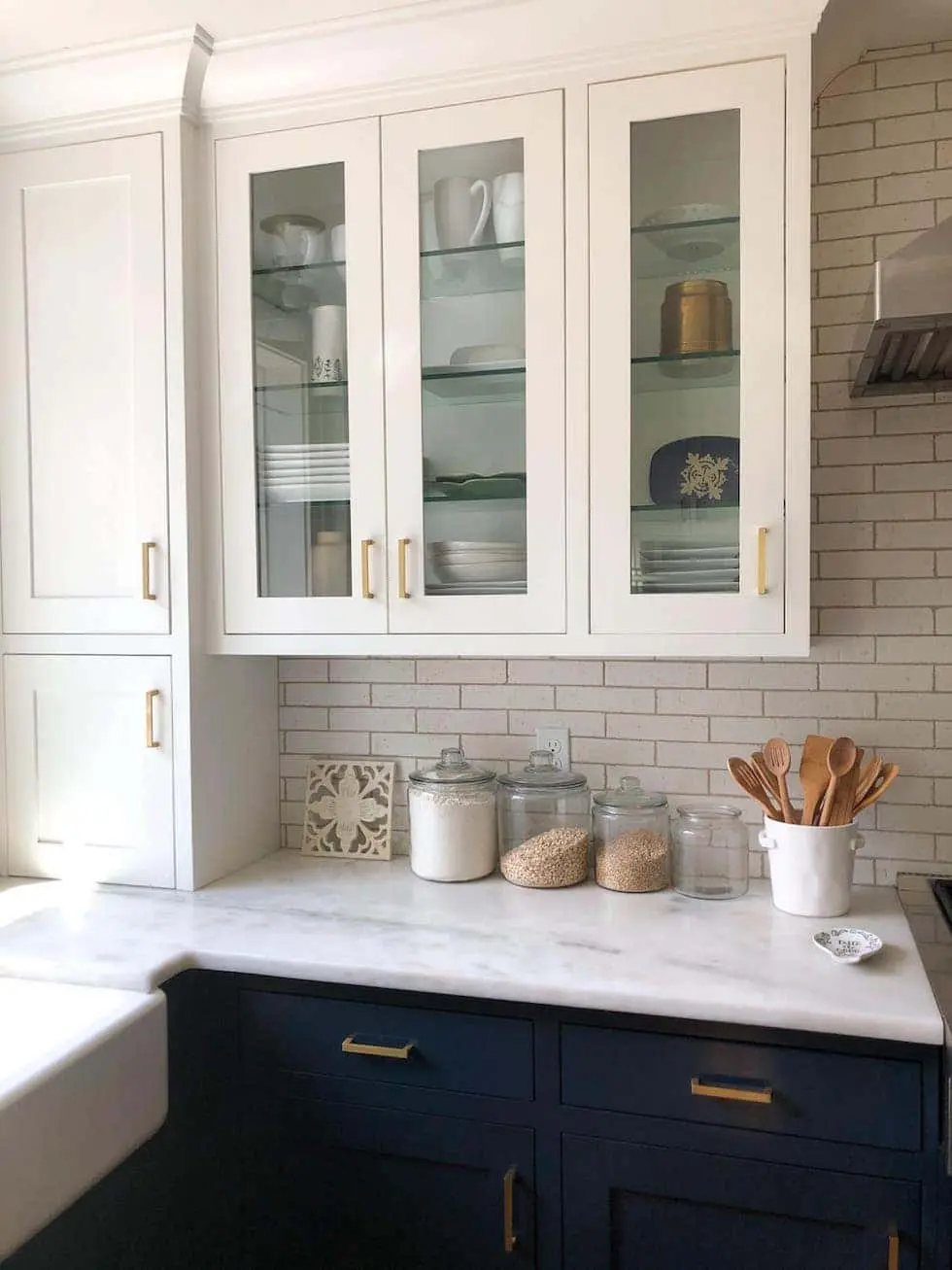 Glass front cabinets with a combination of white and navy blue finishes