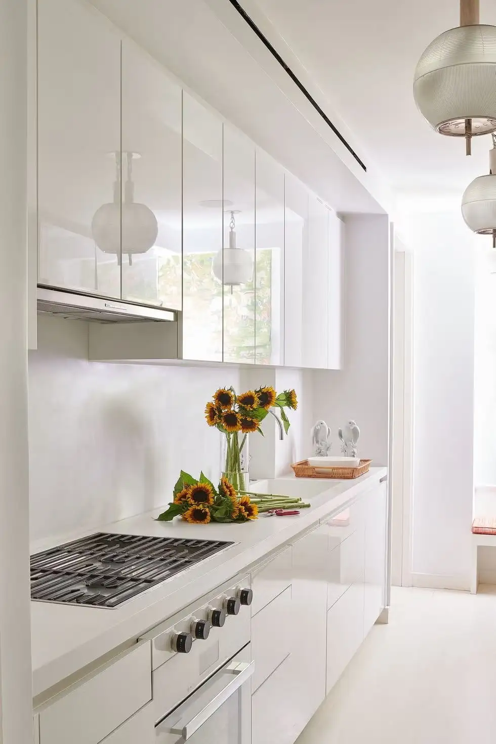 High gloss white cabinets in a modern kitchen with sunflowers