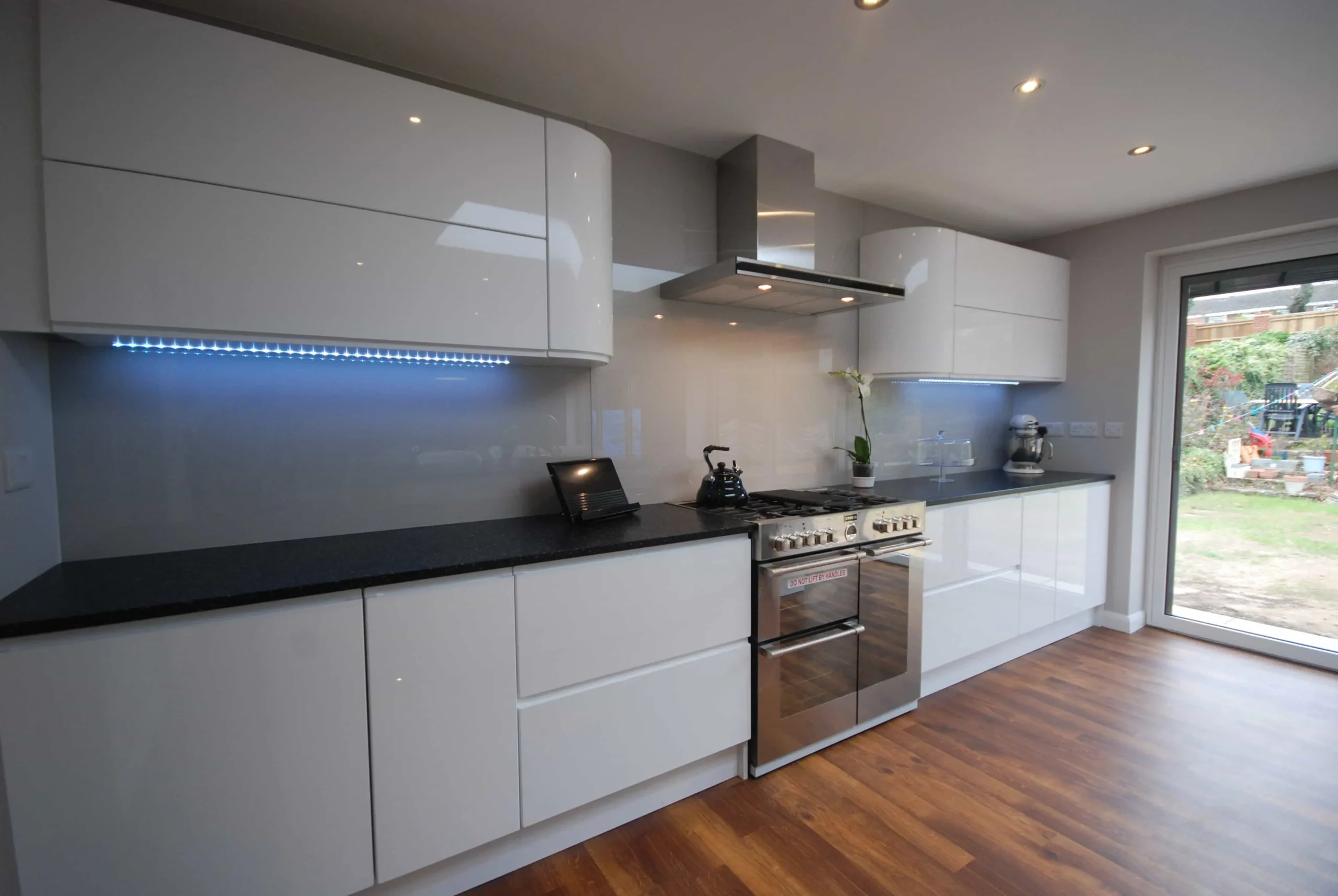 Kitchen with high gloss white cabinets and black countertops Kitchen with high gloss white cabinets and black countertops