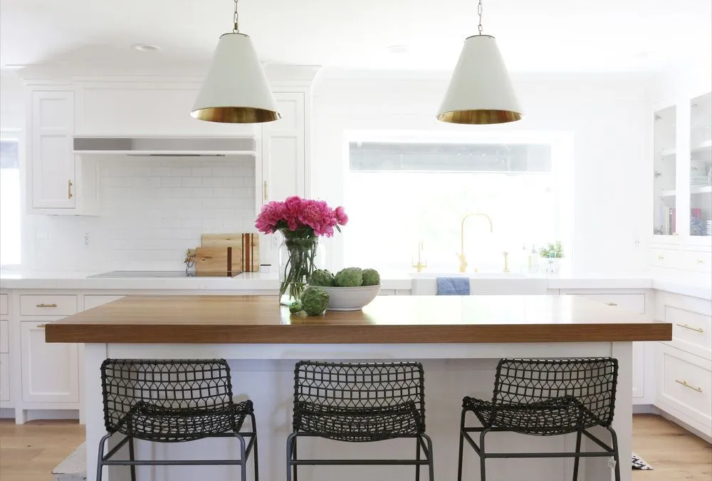 Modern kitchen with a butcher block countertop and white cabinetry Modern kitchen with a butcher block countertop and white cabinetry