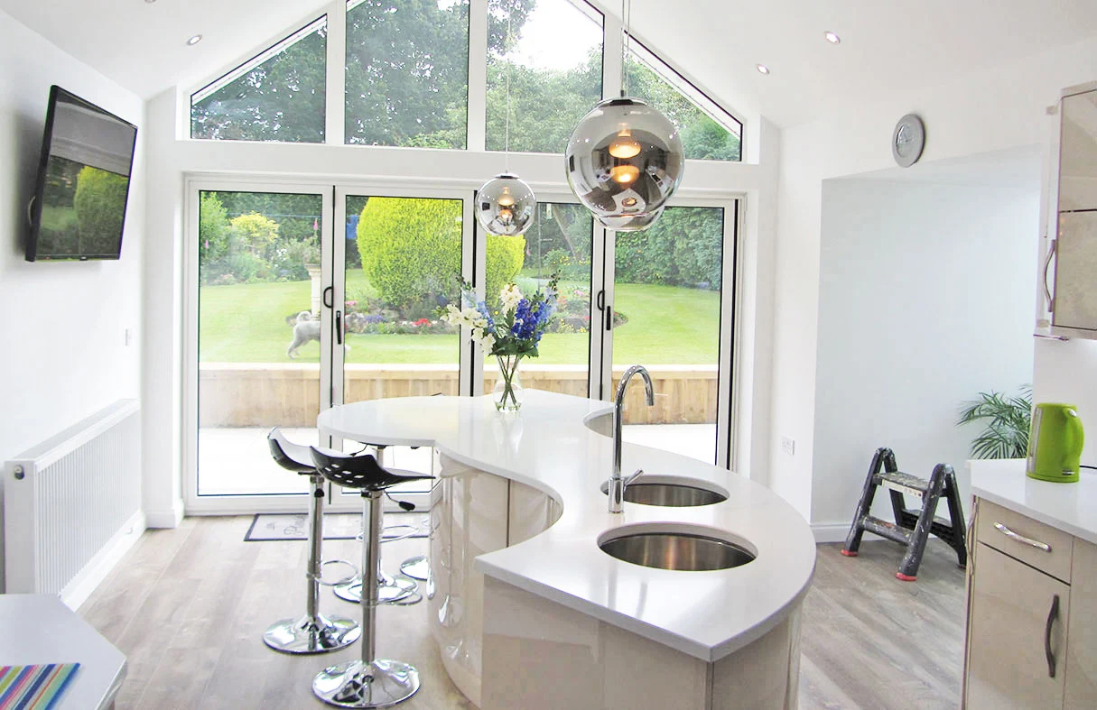 Modern kitchen with a sleek curved island and large garden view Modern kitchen with a sleek curved island and large garden view