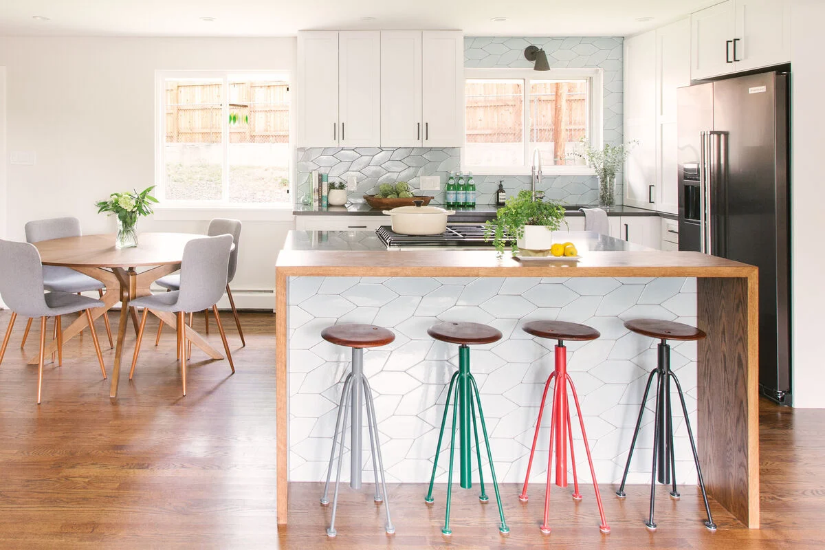 Personalized kitchen island with unique tile inlays and colorful stools Personalized kitchen island with unique tile inlays and colorful stools