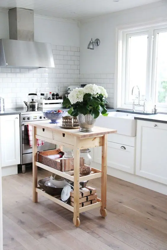 Small kitchen with a wooden cart and farmhouse sink