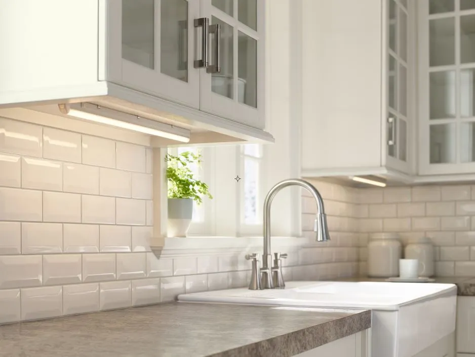 Under cabinet lighting highlights a sleek kitchen backsplash