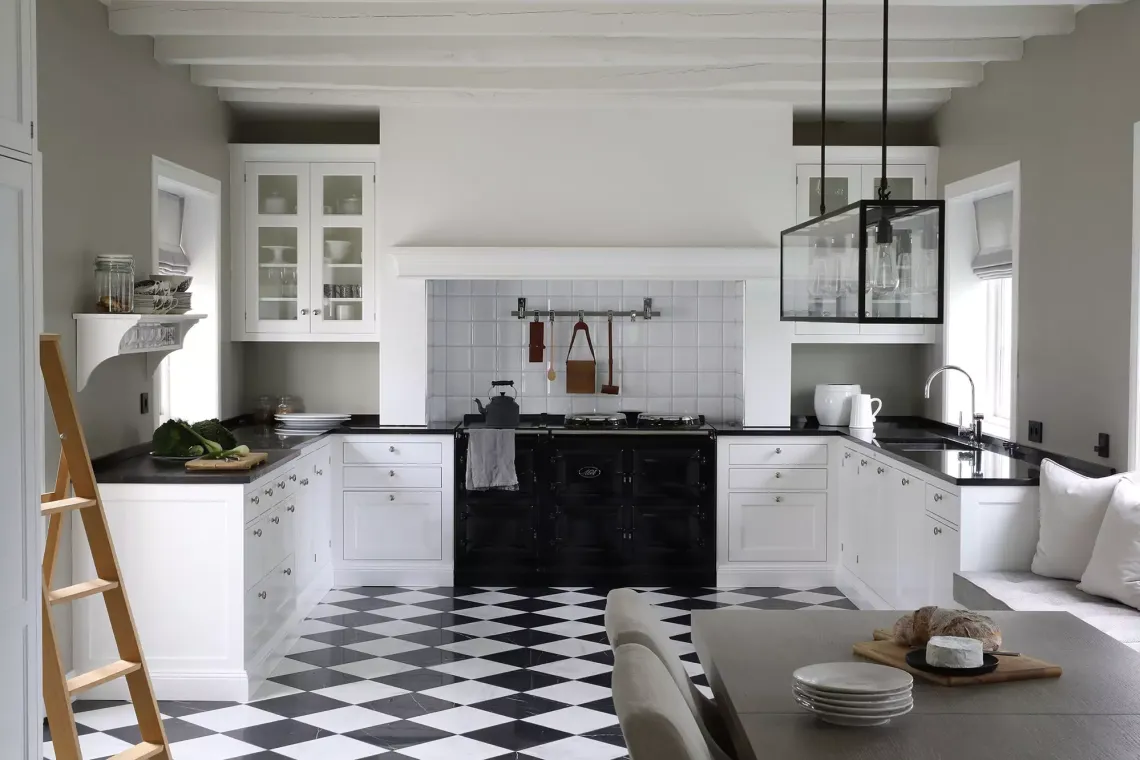 White kitchen with black countertops checkered floor and industrial accents White kitchen with black countertops checkered floor and industrial accents