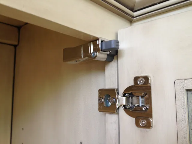 Close up of a kitchen cabinet soft close hinge Close up of a kitchen cabinet soft close hinge