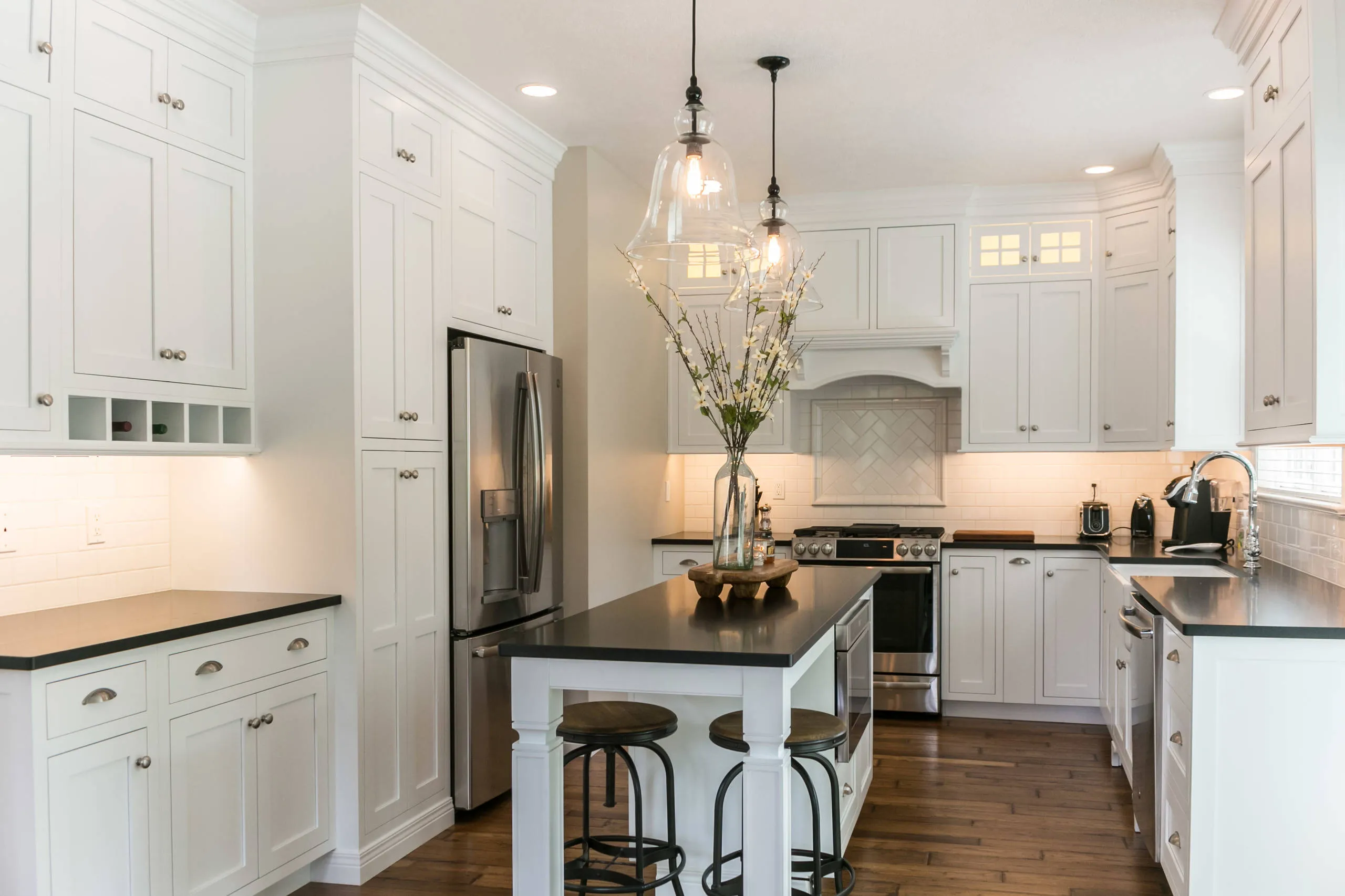 Contemporary kitchen with a mix of white cabinets and dark countertops Contemporary kitchen with a mix of white cabinets and dark countertops