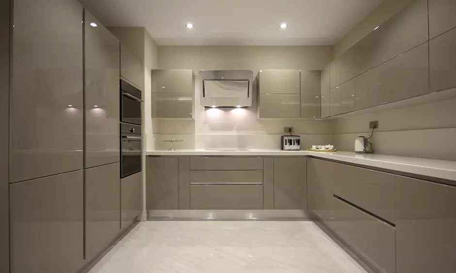 High Gloss Finish Glossy beige cabinets with minimalist handles in modern kitchen