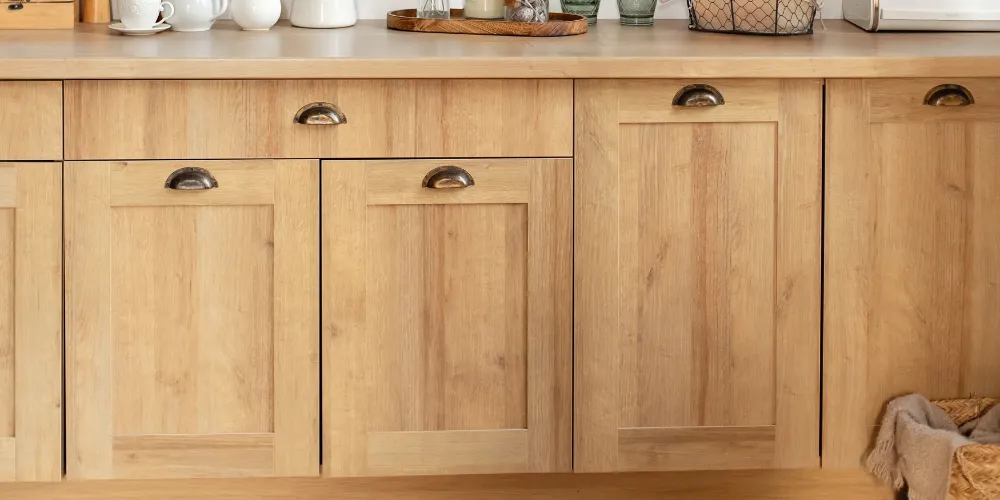 Light wooden kitchen cabinets with dark metal handles Light wooden kitchen cabinets with dark metal handles