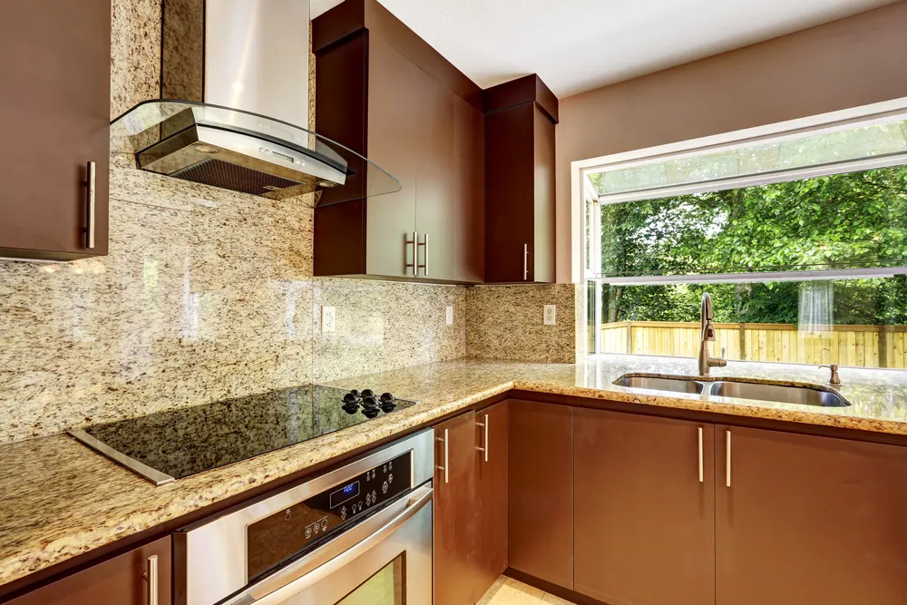 Matte Finish Dark brown cabinets with stone countertops and backsplash