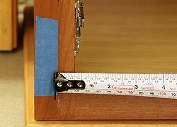 Measuring tape showing a 1 2 inch overlay for kitchen cabinet hinge placement Measuring tape showing a 1 2 inch overlay for kitchen cabinet hinge placement