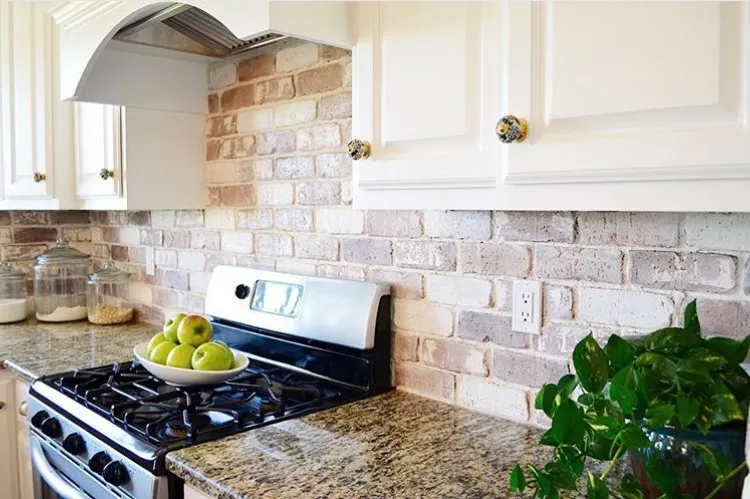 Modern kitchen with brick veneer backsplash and white cabinetry Modern kitchen with brick veneer backsplash and white cabinetry