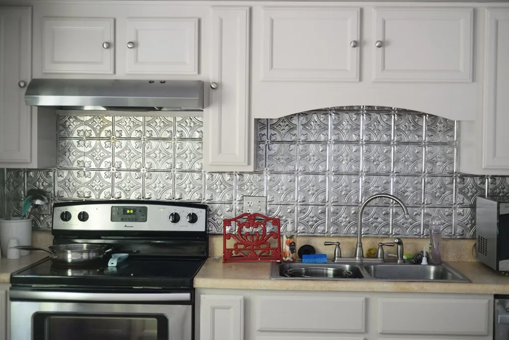 Modern kitchen with metallic backsplash and white cabinets Modern kitchen with metallic backsplash and white cabinets