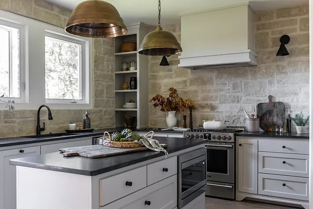 Modern kitchen with natural stone backsplash and warm lighting