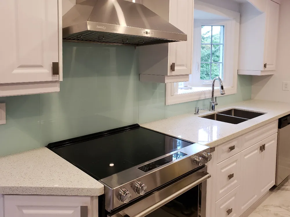 Modern kitchen with sleek glass backsplash and white cabinets Modern kitchen with sleek glass backsplash and white cabinets