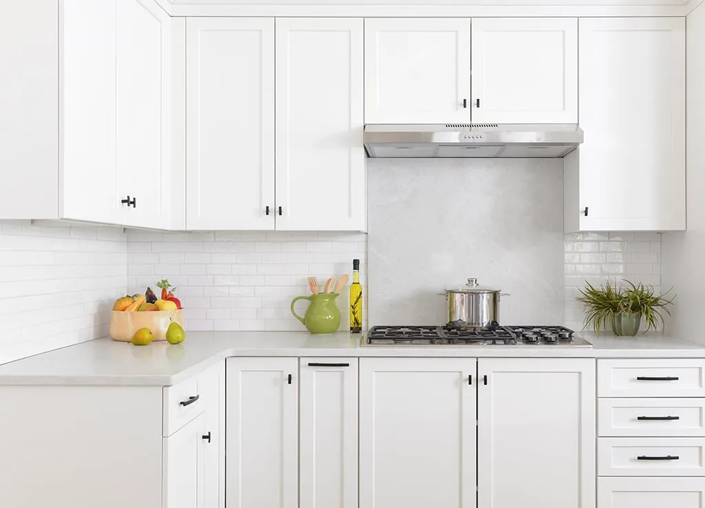 Modern white kitchen cabinets with a stove and countertop accessories Modern white kitchen cabinets with a stove and countertop accessories