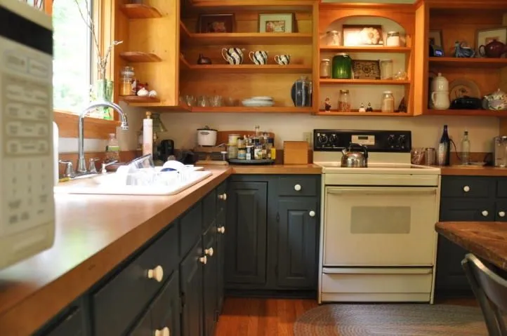 Navy base cabinets with honey oak uppers in a cozy kitchen