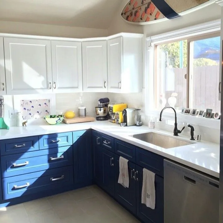 Powder blue base cabinets paired with cream uppers in a two tone kitchen