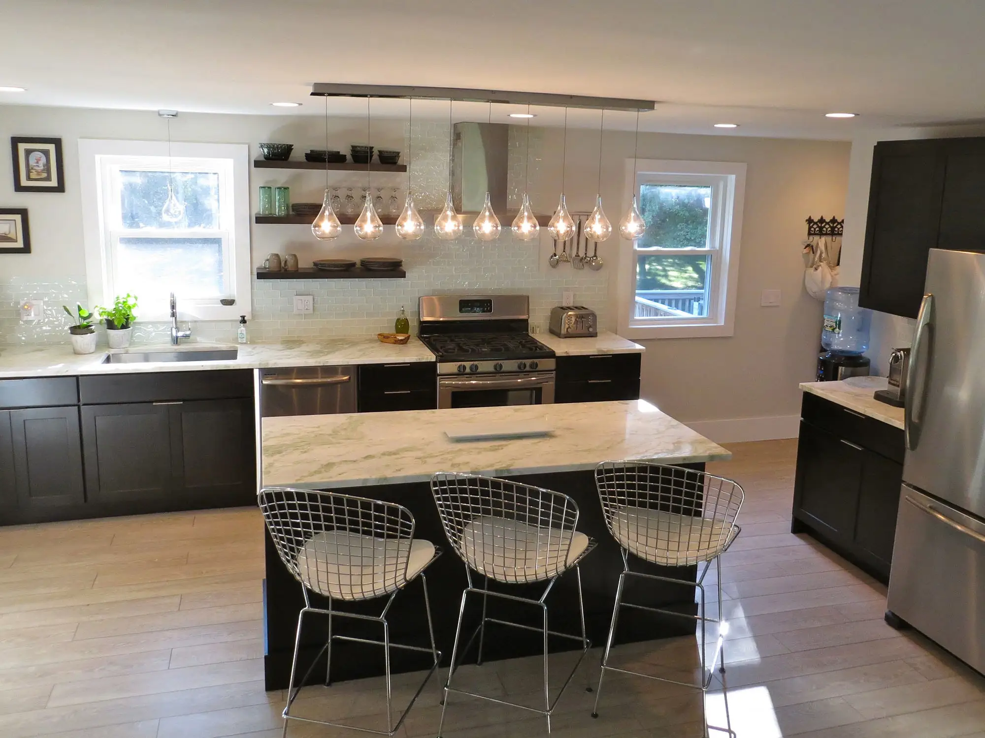 Black and white kitchen with large island and hanging lights Black and white kitchen with large island and hanging lights