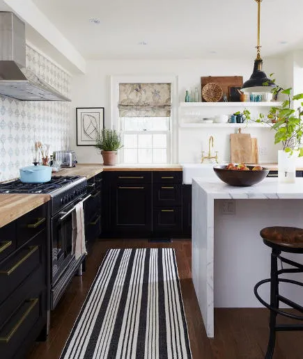 Black cabinets with a striped rug and bright kitchen island Black cabinets with a striped rug and bright kitchen island