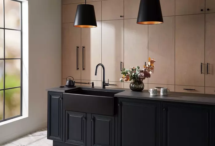 Black sink and cabinets with wood panel accents in kitchen Black sink and cabinets with wood panel accents in kitchen