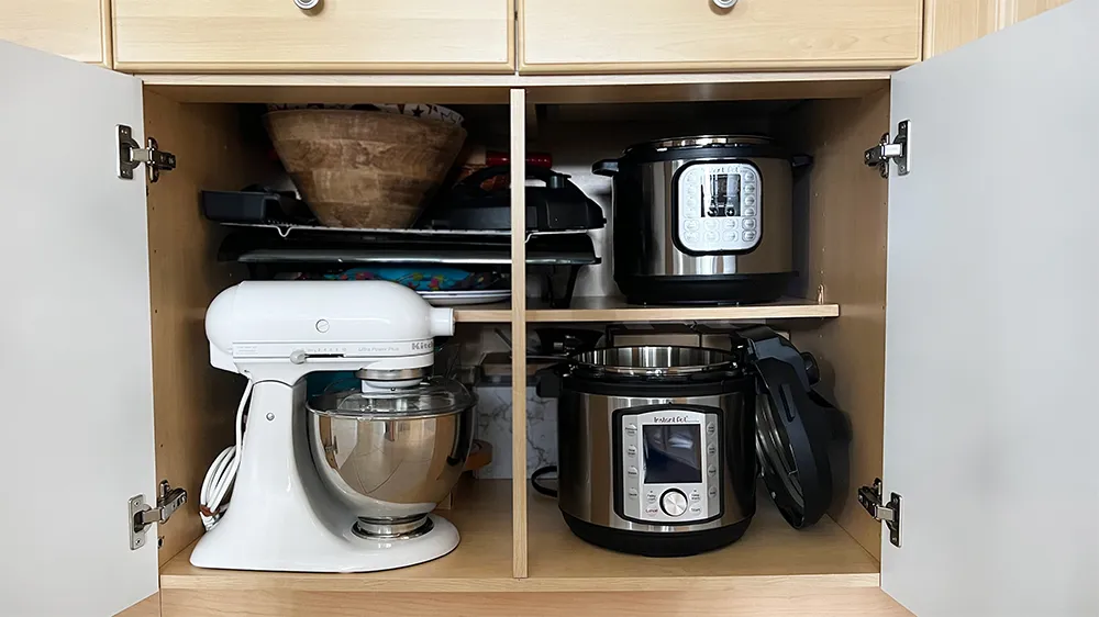 Cabinet neatly organized with kitchen appliances and accessories Cabinet neatly organized with kitchen appliances and accessories