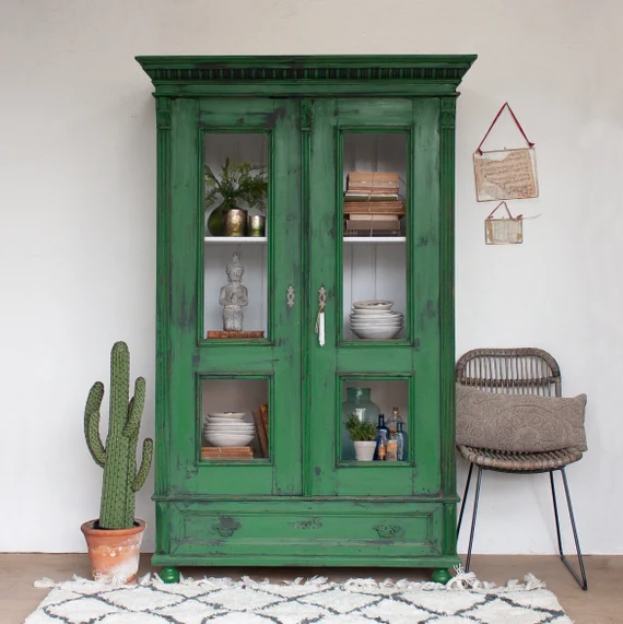 Green vintage cabinet with glass doors and decorative items Green vintage cabinet with glass doors and decorative items