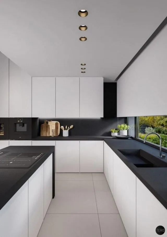 Minimalist kitchen with black countertop and white cabinets