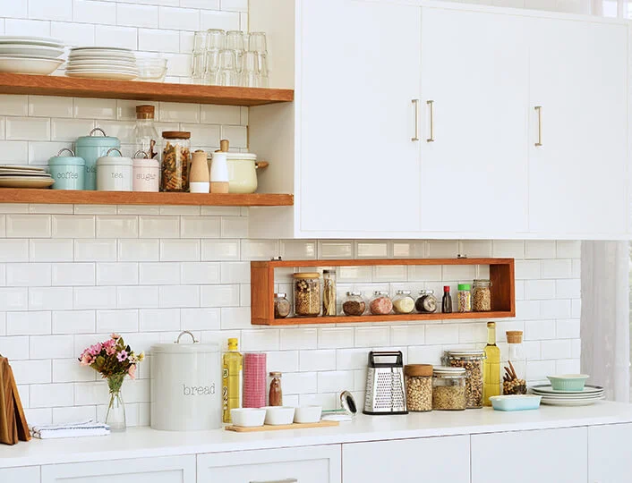 Minimalist kitchen with white tiles jars and wooden shelves Minimalist kitchen with white tiles jars and wooden shelves